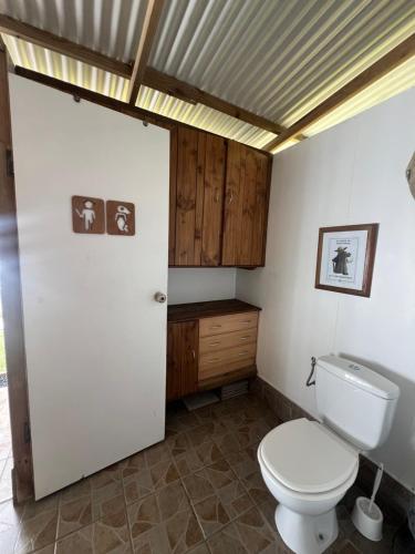 Fare Tetahora في Tevaitoa: حمام مع مرحاض ودواليب خشبية
