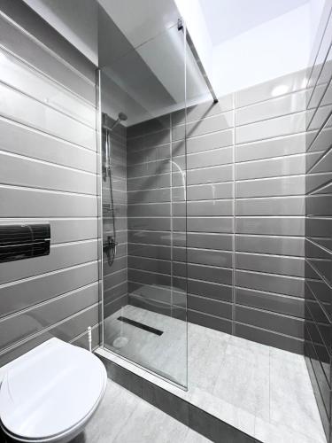 a bathroom with a toilet and a glass shower at Apartament Vivo & Pool access - Free parking in Constanţa