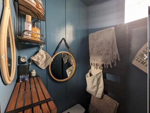łazienka z drewnianą ławką i lustrem w obiekcie Le Chaumontais Écolo w mieście Chaumont