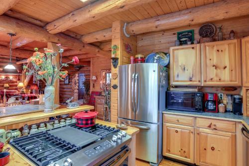 a kitchen with a stove and a refrigerator at Handcrafted Log Home on River Near Crystal Mtn in Thompsonville