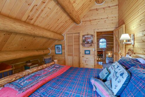 a bedroom with a bed in a log cabin at Handcrafted Log Home on River Near Crystal Mtn in Thompsonville