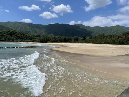 a sandy beach with mountains in the background at Yoka House - Vacation STAY 46247v in Tokunoshima