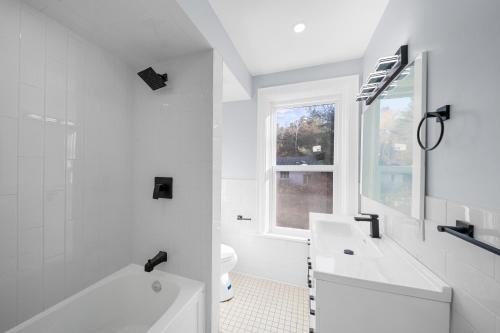 uma casa de banho branca com uma banheira e um lavatório em 2BDRM LUXURY NEWLY RENOVATED HOUSE with Game room, XBOX , POOL TABLE em Vaughan