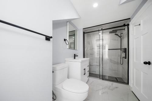 biała łazienka z toaletą i prysznicem w obiekcie 2BDRM LUXURY NEWLY RENOVATED HOUSE with Game room, XBOX , POOL TABLE w mieście Vaughan