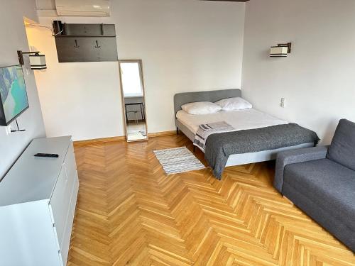 - une petite chambre avec un lit et un canapé dans l'établissement APART WAWA app 38 WiFi 600 Mbit, à Varsovie