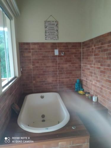 a bath tub in a room with a brick wall at Bangalôs Cavalcante in Cavalcante