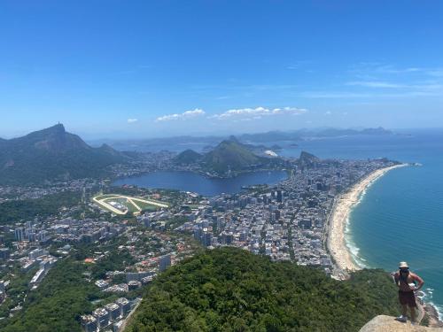 a man standing on top of a mountain overlooking a city at Studio Reformado coração Leblon in Rio de Janeiro