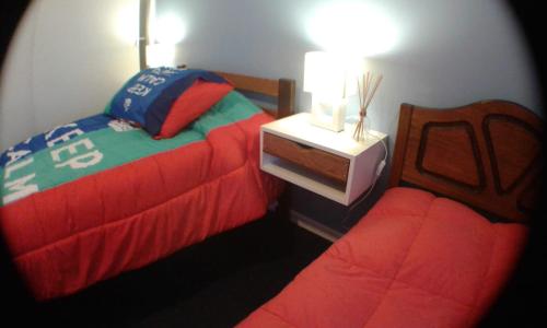 um quarto com duas camas e uma mesa de cabeceira com uma cama sidx sidx em Hostal San Valentín em Concepción