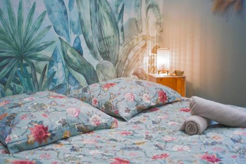 - un lit avec 2 oreillers et une fresque murale dans l'établissement Tropicoon Room jacuzzi centre ville parking free, à Mulhouse