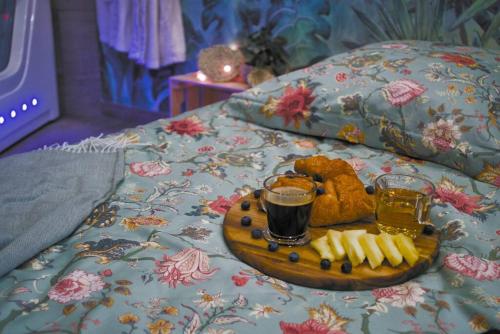 un plateau de nourriture et de boissons sur un lit dans l'établissement Tropicoon Room jacuzzi centre ville parking free, à Mulhouse