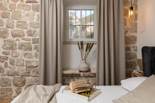 a bedroom with a stone wall and a window at Nono's House I in Dubrovnik