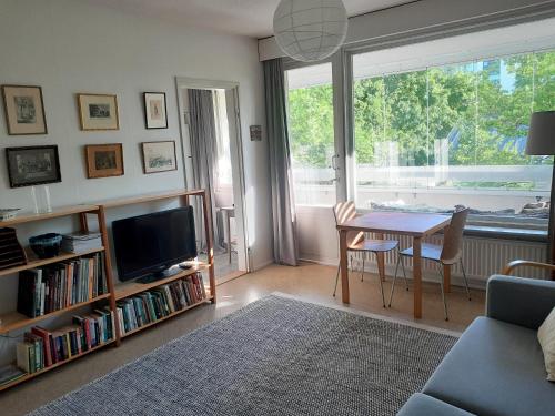 a living room with a table and a tv at Peaceful apartment on Sofiankatu Turku Center Free parking in Turku