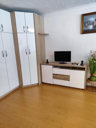 a living room with a television and white cabinets at Ferienwohnung - Apartment Pichlarn Holiday in Aigen im Ennstal