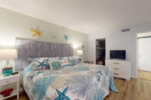 a bedroom with a bed with a blue and white comforter at 202 - Sandy Shores in St. Pete Beach