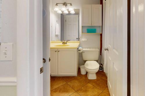 a bathroom with a white toilet and a sink at 202 - Sandy Shores in St. Pete Beach