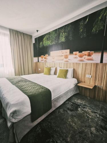 a bedroom with a large bed and a painting on the wall at YMY Boutique Residence in Bucharest