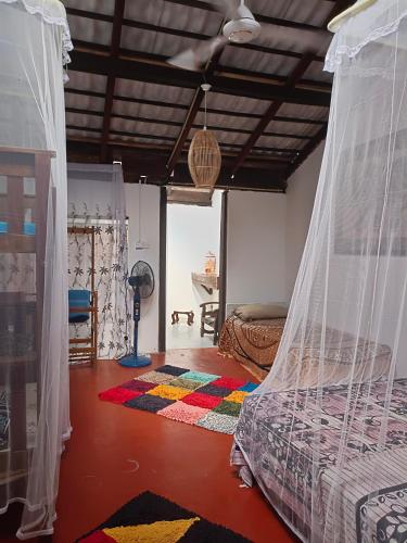 a bedroom with a bed with a mosquito net at Mamisa Café, Home stay in Habarana