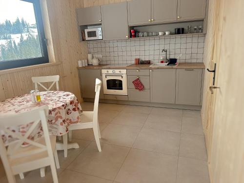 eine Küche mit einem Tisch, einem Tisch und Stühlen in der Unterkunft Cicho Tu in Bukowina Tatrzańska