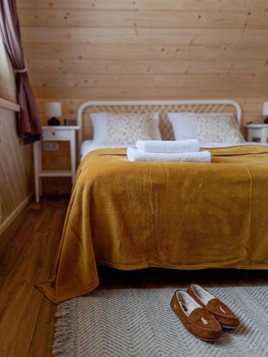 a bedroom with a bed with two pairs of shoes on it at Cicho Tu in Bukowina Tatrzańska