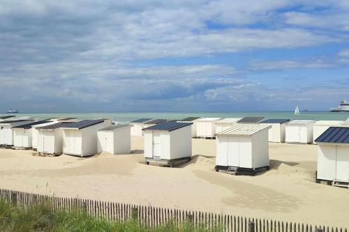 a row of beach huts on a sandy beach at Studio Calais Front de mer-Le Cocon du Dragon-Classé 3 etoiles in Calais