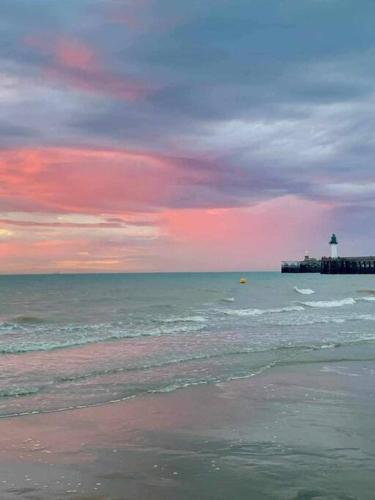 a view of the ocean with a lighthouse in the distance at Studio Calais Front de mer-Le Cocon du Dragon-Classé 3 etoiles in Calais