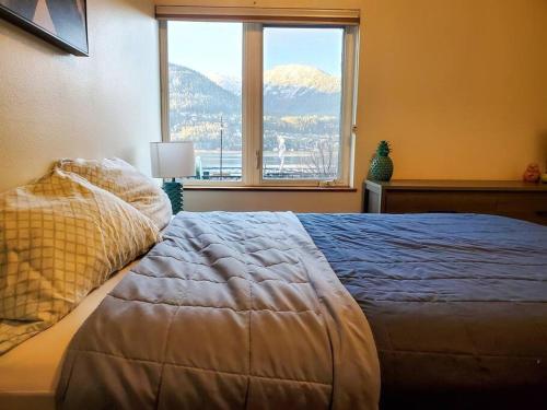 a bedroom with a large bed with a large window at Downtown Juneau Gem: 1BR Apt with Stunning Views! in Juneau