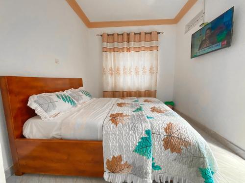 een slaapkamer met een bed met een dekbed erop bij Agape House in Kisoro