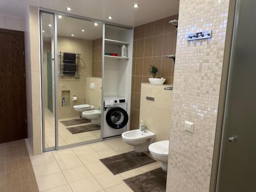 een badkamer met 2 toiletten en een inloopdouche bij Apartamentai in Marijampolė