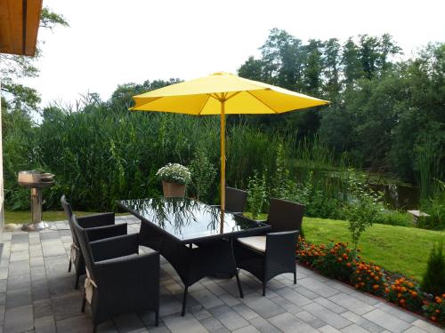 a table with a yellow umbrella on a patio at Ferienoase an der Wublitz in Potsdam