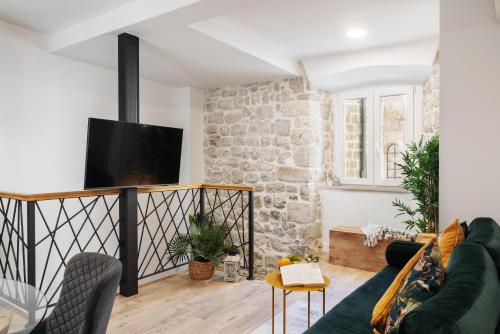 ein Wohnzimmer mit einem Sofa und einem TV in der Unterkunft Nono's House II in Dubrovnik