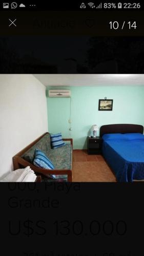 - une chambre avec un lit bleu et un canapé dans l'établissement Casa Lula PLAYA GRANDE, à Playa Hermosa