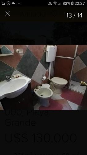 La salle de bains est pourvue d'un lavabo et de toilettes. dans l'établissement Casa Lula PLAYA GRANDE, à Playa Hermosa