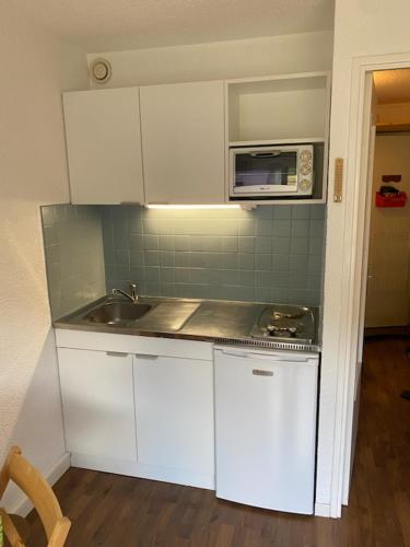 Il comprend une petite cuisine équipée d'un évier et d'un four micro-ondes. dans l'établissement Appartement pied des pistes, à Puy-Saint-Vincent