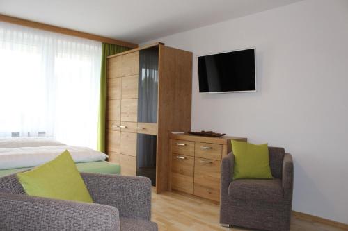 a bedroom with a bed and two chairs and a television at Studio für 3 Personen ca 34 qm in Kaprun, Salzburger Land Kapruner Tal in Kaprun
