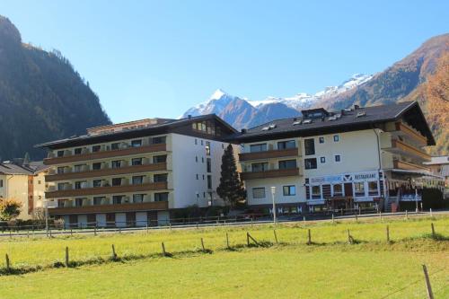 a hotel in a field with mountains in the background at Studio für 3 Personen ca 34 qm in Kaprun, Salzburger Land Kapruner Tal in Kaprun