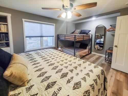 una camera da letto con un letto e un ventilatore a soffitto di Okoboji BLUEtiful Cottage ad Arnolds Park