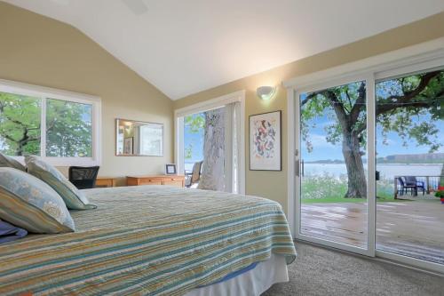1 dormitorio con cama y ventana grande en The Lakeside Lookout on Gingles Point, en Arnolds Park