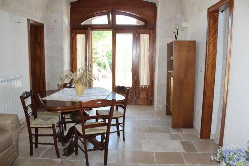 a dining room with a table and chairs and a window at Trulli Sulla Valle in Locorotondo