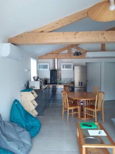 une cuisine et une salle à manger avec une table et des chaises dans l'établissement Maison neuve plain-pied à 400m de la plage, jardin, garage, à La Tranche-sur-Mer