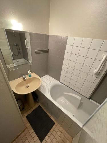 Chez Gustou في شودز آيْج: حمام مع حوض وحوض استحمام ومغسلة