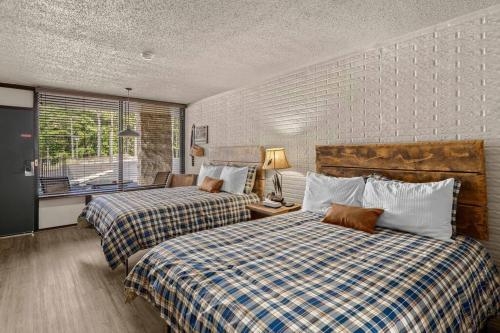 a bedroom with two beds and a window at Stonegate Lodge 2mi to Historic DTWN Pool WiFi 2 Queen Beds Room #210 in Eureka Springs