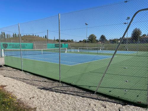 una pista de tenis con red en una pista de tenis en Mobilhome, en Castillonnès