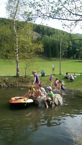 a group of children sitting on a rock in the water at Hotel Alpenfrieden in Rio Bianco