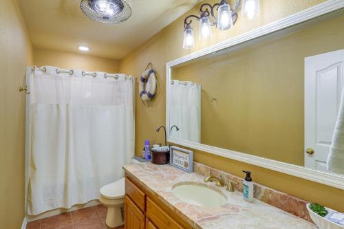 La salle de bains est pourvue d'un lavabo, de toilettes et d'un miroir. dans l'établissement Greers Ferry Lake Vacation Rental with Porch and View!, à Heber Springs