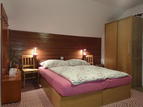 una camera con un grande letto con testiera in legno di Privat Sabaka - Chalupa pod Kriváňom vo Východnej a Východná