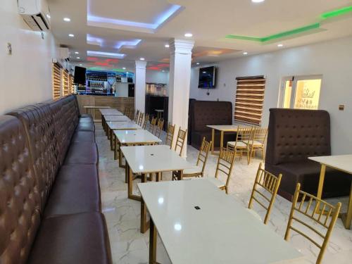 een eetkamer met tafels en stoelen in een restaurant bij B&Y ROYAL BAR & LOUNGE ADIGBE ROAD ABEOKUTA NEAR ADIGBE POLICE STATION AFTER PANSEKE in Abeokuta