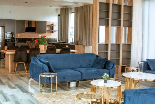 salon z niebieską kanapą i stołami w obiekcie Vista Heights Residence w mieście Kigali