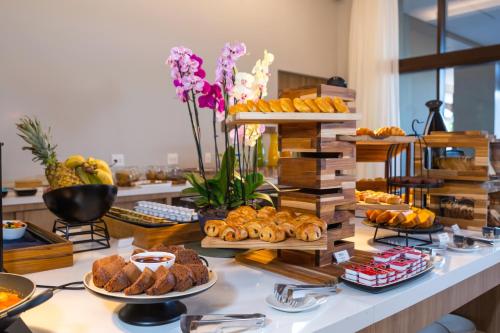 a buffet with various types of bread and pastries at Hilton Garden Inn São José do Rio Preto in Sao Jose do Rio Preto