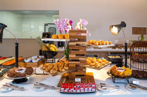 a buffet with many different types of food on a table at Hilton Garden Inn São José do Rio Preto in Sao Jose do Rio Preto
