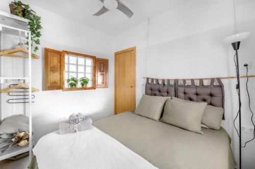 1 dormitorio con 1 cama con cabecero y ventana en La Bombonera en Catadau